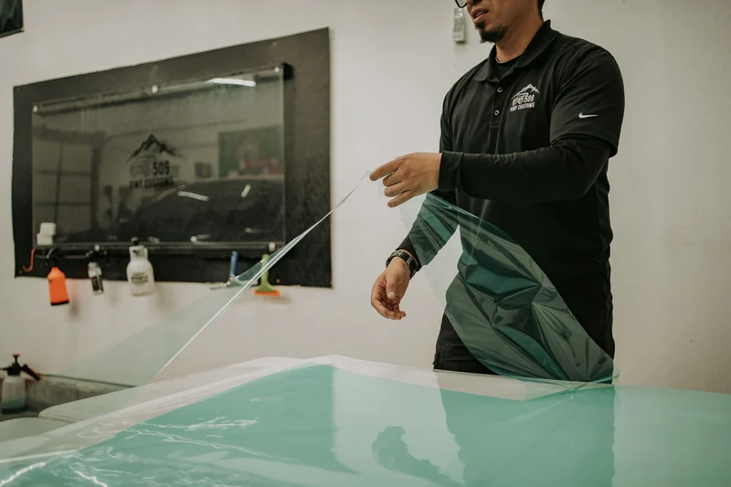 Technician preparing paint protection film at the workbench
