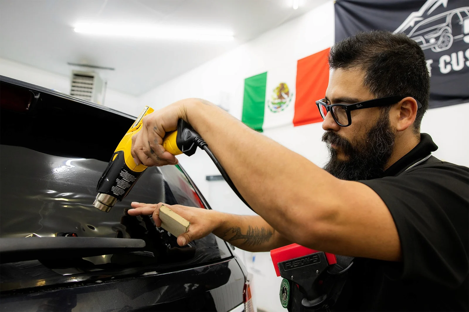 509 Tint Customs technician shaping automotive window film with a heat gun